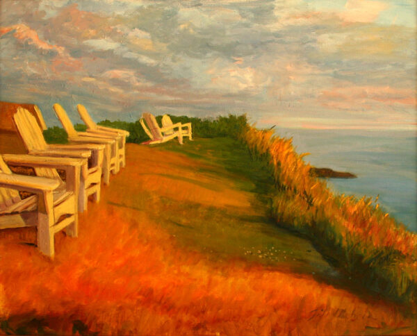 Monhegan Adirondacks sit on the hill over the harbor soaking in the Monhegan Island Sunset